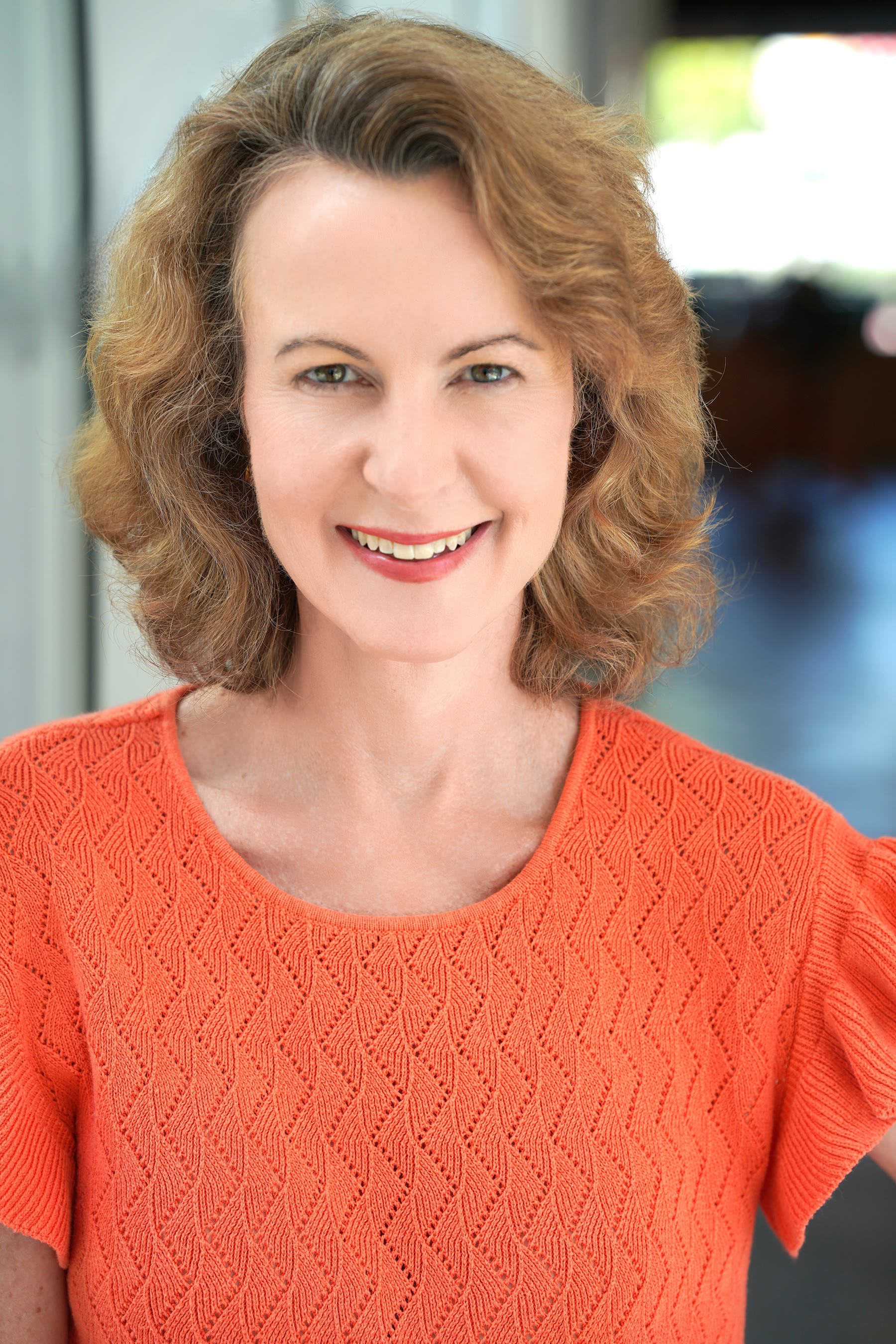 Grace H Bryan orange top headshot