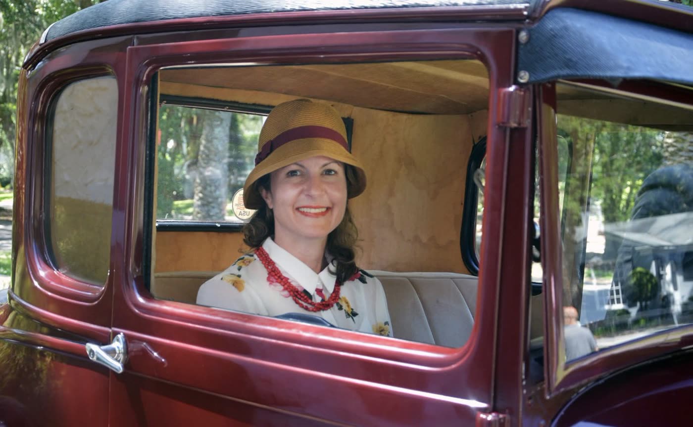 Grace H Bryan in a period costume seated in a car